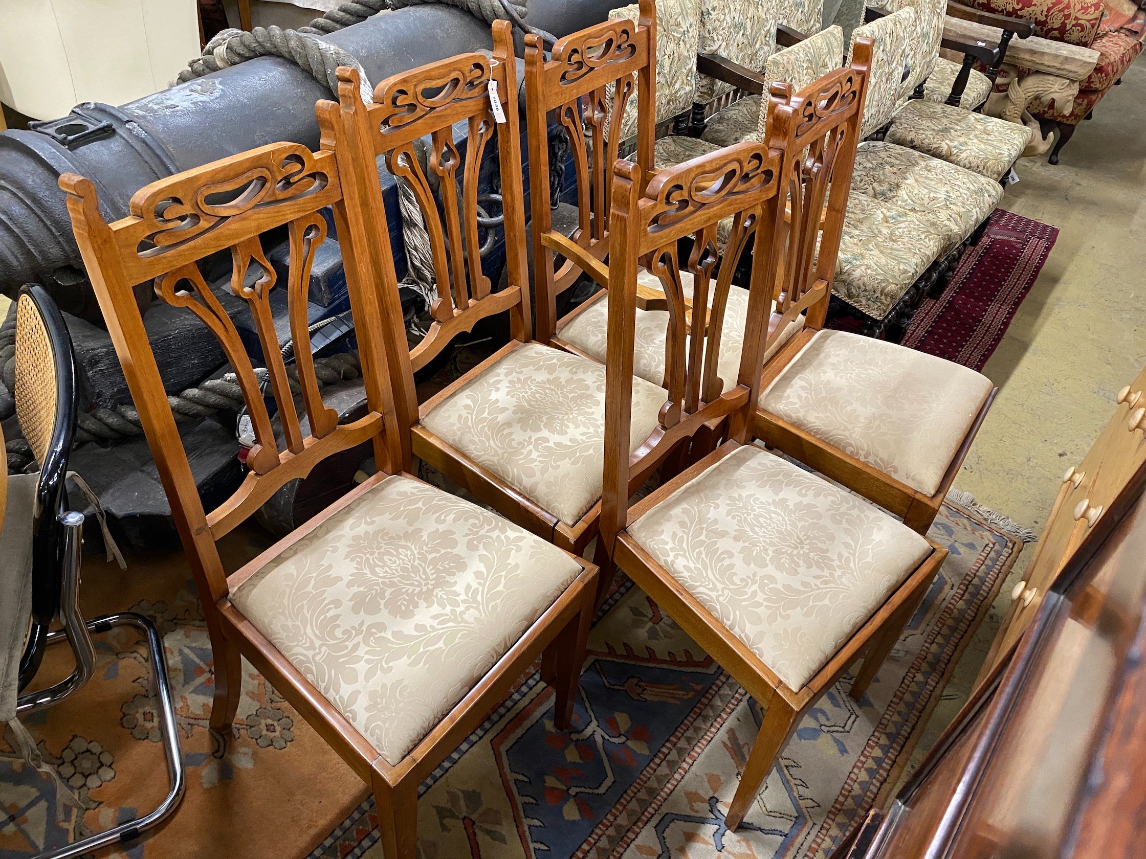 Five Art Nouveau walnut dining chairs, one with arms
